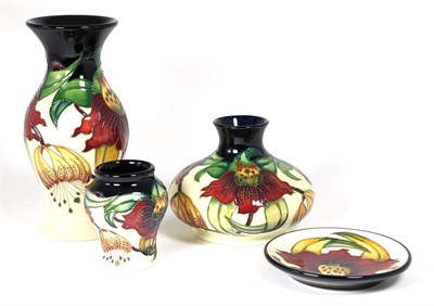 Lot 125 - Modern Moorcroft Pottery: three Anna Lily vases, tallest 19.5cm high, and a coaster in the same...