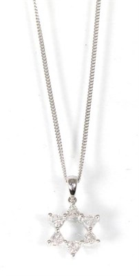 Lot 256 - An 18 carat white gold diamond star pendant, on chain, six trilliant cut diamonds in claw...