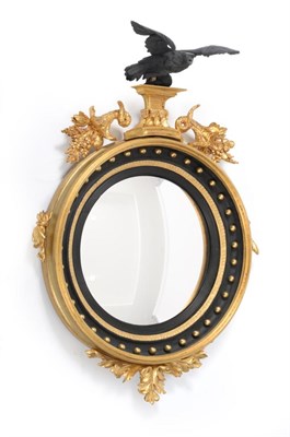 Lot 1204 - A Regency Gilt, Gesso and Ebonised Convex Wall Mirror, early 19th century, with ball surmounted...