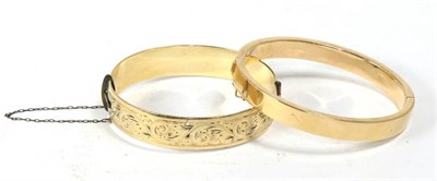 Lot 515 - A yellow metal bangle stamped 585 together with a gold plated bangle (2)