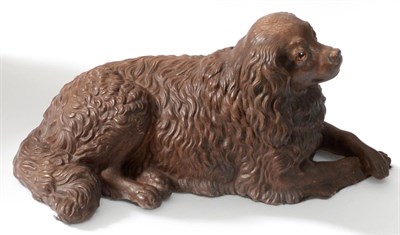 Lot 75 - An Austrian Painted Terracotta Figure of a Spaniel, circa 1900, recumbent, with glass eyes,...