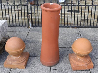 Lot 1159 - Two terracotta ball finials, together with a terracotta chimney pot