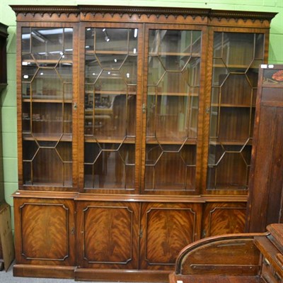 Lot 1256 - A reproduction Georgian style break front bookcase, with dentil and arcaded cornice over...