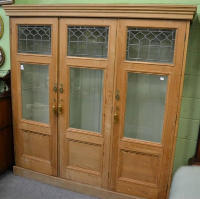 Lot 1258 - A stripped pine cupboard with glazed and leaded panelled doors