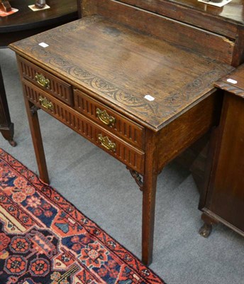 Lot 1284 - A carved oak three drawer side table decorated with lunettes