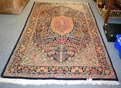 Lot 1309 - Kirman rug, South East Iran, the indigo field with a candy pink panel enclosed by meandering...