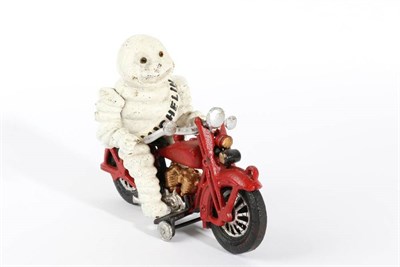 Lot 1135 - A Michelin Cast Metal Advertising Figure, modelled as the Michelin Man riding a red motorcycle,...
