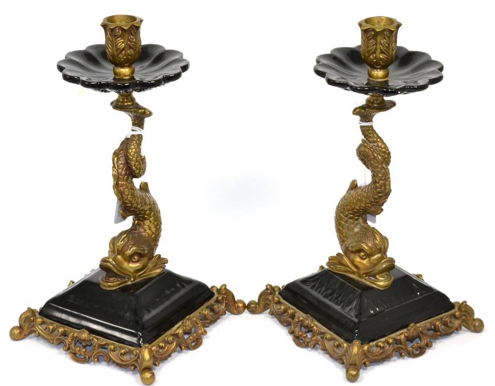 Lot 39 - A pair of brass and pottery dolphin candlesticks