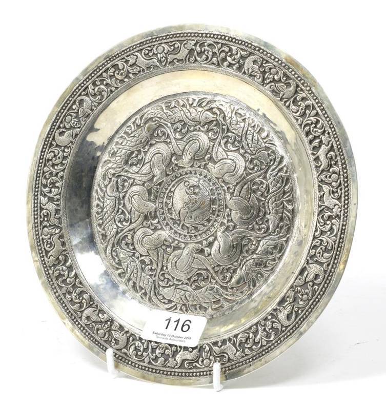 Lot 116 - A Middle Eastern or Indian white metal repousse decorated dish, decorated with borders of animals