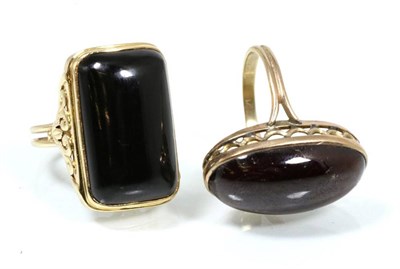 Lot 171 - An onyx dress ring, with fancy scroll shoulders and split shank, finger size Q1/2, inscribed '14K'