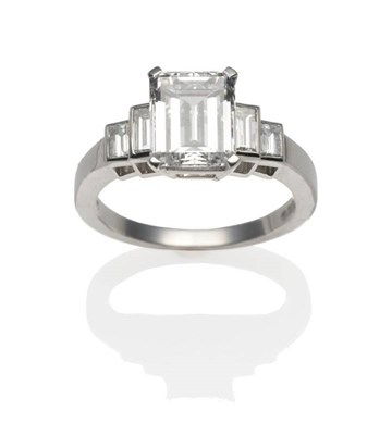 Lot 177 - A Platinum Diamond Ring, an emerald-cut diamond in a white claw setting, to shoulders each set with