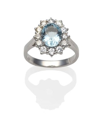 Lot 189 - An 18 Carat White Gold Aquamarine and Diamond Cluster Ring, an oval cut aquamarine within a...