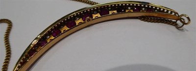Lot 257 - A ruby and diamond crescent necklace, graduated round cut rubies spaced by rough cut diamonds,...