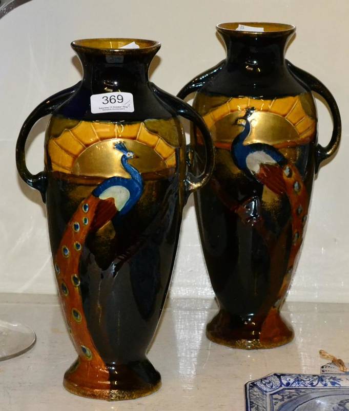 Lot 369 - Phoenix Ware, a pair of twin handled pottery vases decorated with peacocks