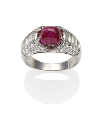 Lot 250 - A Ruby and Diamond Ring, a cabochon ruby in a white claw setting between rows of channel set...