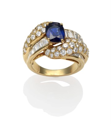 Lot 272 - A Sapphire and Diamond Ring, an oval cut sapphire in a yellow claw setting between scrolling...