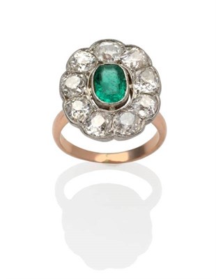 Lot 278 - An Emerald and Diamond Cluster Ring, an oval cut emerald within a border of old cut diamonds,...