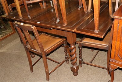 Lot 1291 - An oak drawer leaf table with four dining chairs