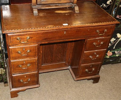 Lot 1315 - A checker-banded oak kneehole desk on bracket feet