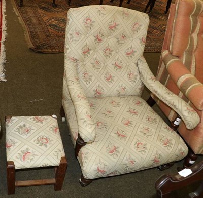 Lot 1337 - An Edwardian upholstered open armchair of Howard style with a later footstool, upholstered to match