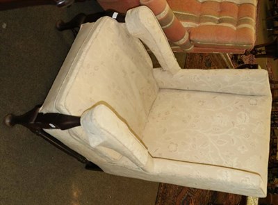 Lot 1339 - An upholstered wing armchair