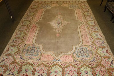 Lot 1345 - A Kirman design carpet, the pale mushroom field centred by a medallion framed by floral borders