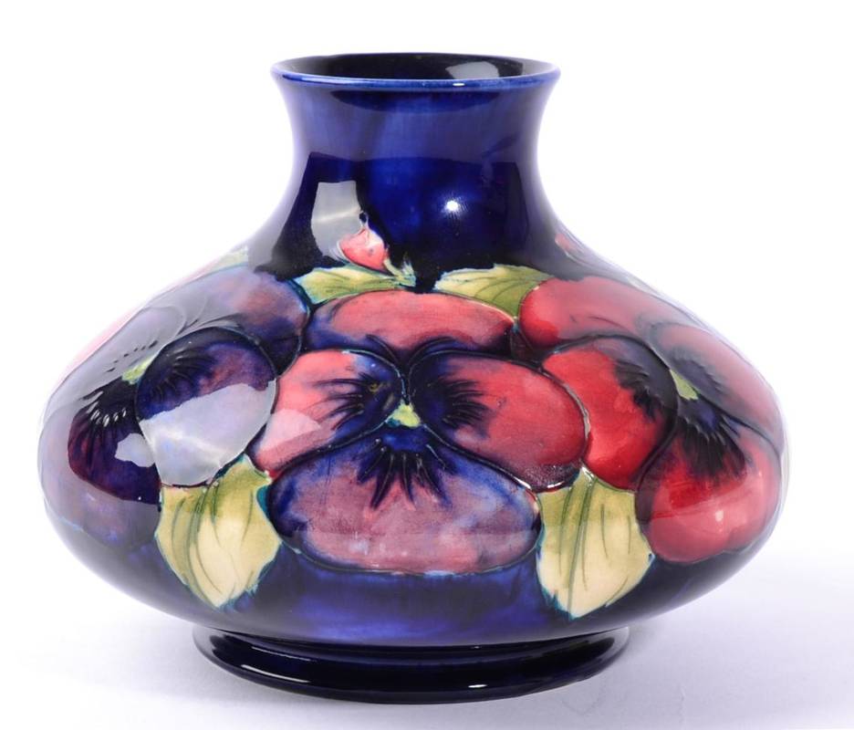 Lot 229 - William Moorcroft (1872-1945): A Pansy Pattern Vase, circa 1930, on a dark blue ground,...