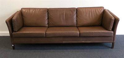 Lot 407 - A 1970s Brown Leather Three-Seater Sofa, by Georg Thams, with slender arms above stained brown...