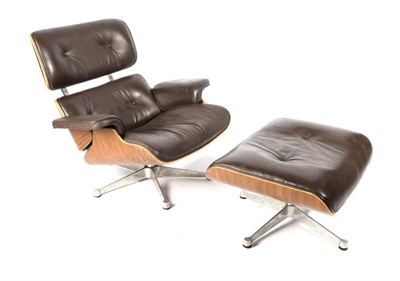 Lot 443 - After Charles and Ray Eames: A Walnut 670 Lounge Chair and 671 Ottoman, modern, with brown...