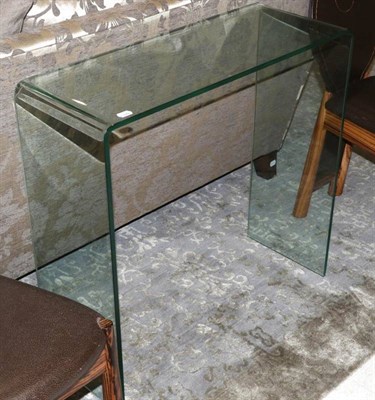 Lot 484 - A Glass Console Table, modern, of curved form, 80cm by 30cm by 76cm