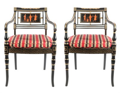 Lot 510 - A Pair of Regency Style Ebonised and Parcel Gilt Armchairs, modern, with striped squab cushions...