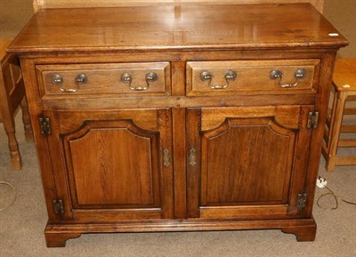 Lot 548 - An Oak Sideboard, modern, with two long drawers above two cupboard doors, on bracket feet, 113cm by