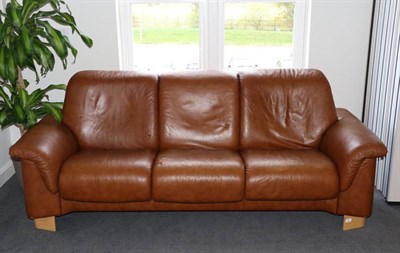 Lot 567 - An Erkorns Stressless Brown Leather Three-Seater Reclining Sofa, modern, on beech curved legs,...