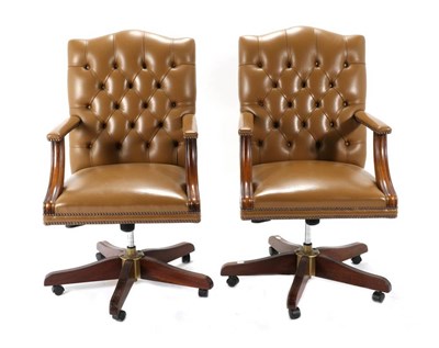 Lot 578 - A Pair of Close-Nailed Brown Leather Executive Swivel Office Armchairs, modern, with button...