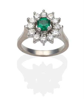 Lot 305 - An Emerald and Diamond Cluster Ring, an octagonal cut emerald within a border of round...