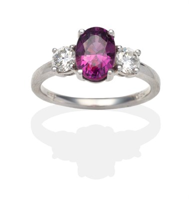 Lot 366 - An 18 Carat White Gold Purple Sapphire and Diamond Three Stone Ring, an oval cut purple...