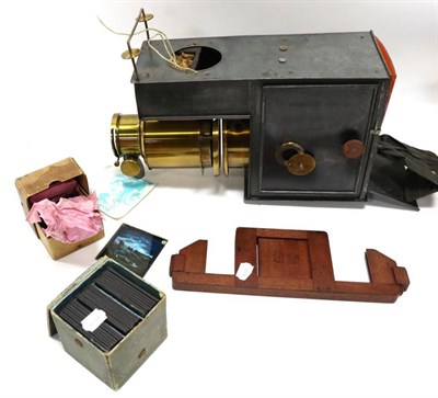 Lot 1274 - Magic Lantern brass 7'' lens with rack and pinion focussing in tin box, together with two boxes...