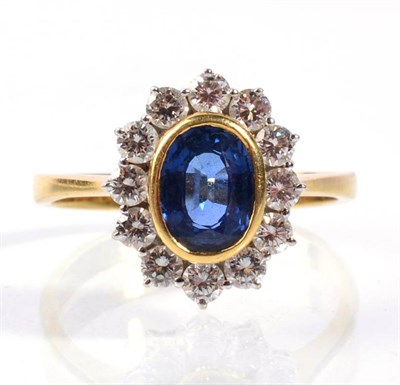 Lot 68 - An 18 carat gold sapphire and diamond cluster ring, an oval cut sapphire in a rubbed over...