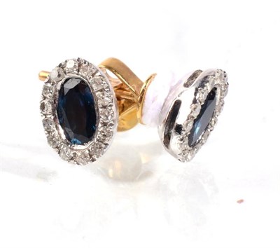 Lot 86 - A pair of sapphire and diamond cluster earrings, an oval cut sapphire within a border of round...