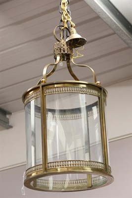 Lot 829 - A Regency Style Brass Hall Lantern, of cylindrical form with four glass panels enclosed by...