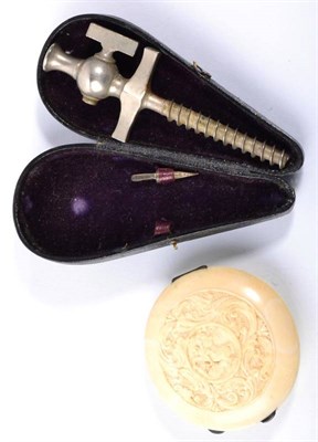 Lot 166 - A 19th century carved ivory compact together with a 19th century wine tap in case (2)