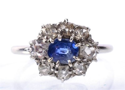 Lot 167 - A sapphire and diamond cluster ring; an oval cut sapphire within a border of old cut diamonds...
