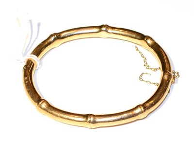 Lot 310 - A bamboo motif bangle, measures 5cm by 6cm, stamped '15CT', 16.3g