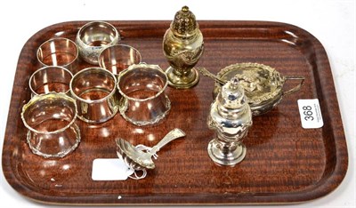 Lot 368 - A silver caddy spoon; seven silver napkin rings; and a three piece condiment set