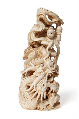 Lot 145 - A Japanese Ivory Okimono, Meiji period (1868-1912), carved with a boy holding an orb sitting on...