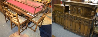 Lot 1217 - A reproduction oak dining suite comprising a table; six chairs; a sideboard; and a drinks...