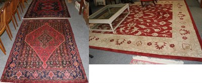 Lot 1278 - A machine made carpet of Agra design, the blood red field of semi naturalistic vines enclosed...