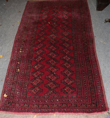 Lot 1284 - Turkmen rug North West Afghanistan, the claret field with three rows of guls enclosed by...