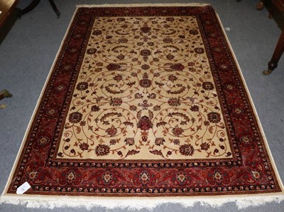 Lot 1286 - An artificial silk machine made rug, the ivory ground of scrolling vines enclosed by palmette...