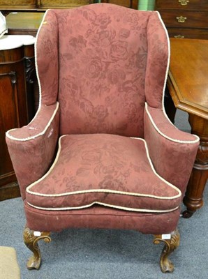 Lot 1363 - A red upholstered wing back armchair